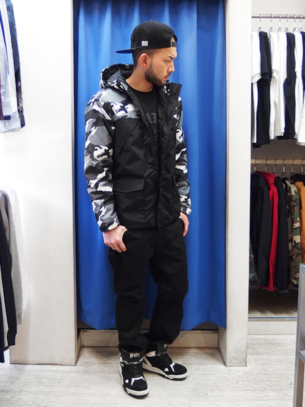 その他のマウンテンパーカー、ブラック系のチノパンツ、ブラック系のキャップを着用したメンズの冬コーディネートの1枚目の写真