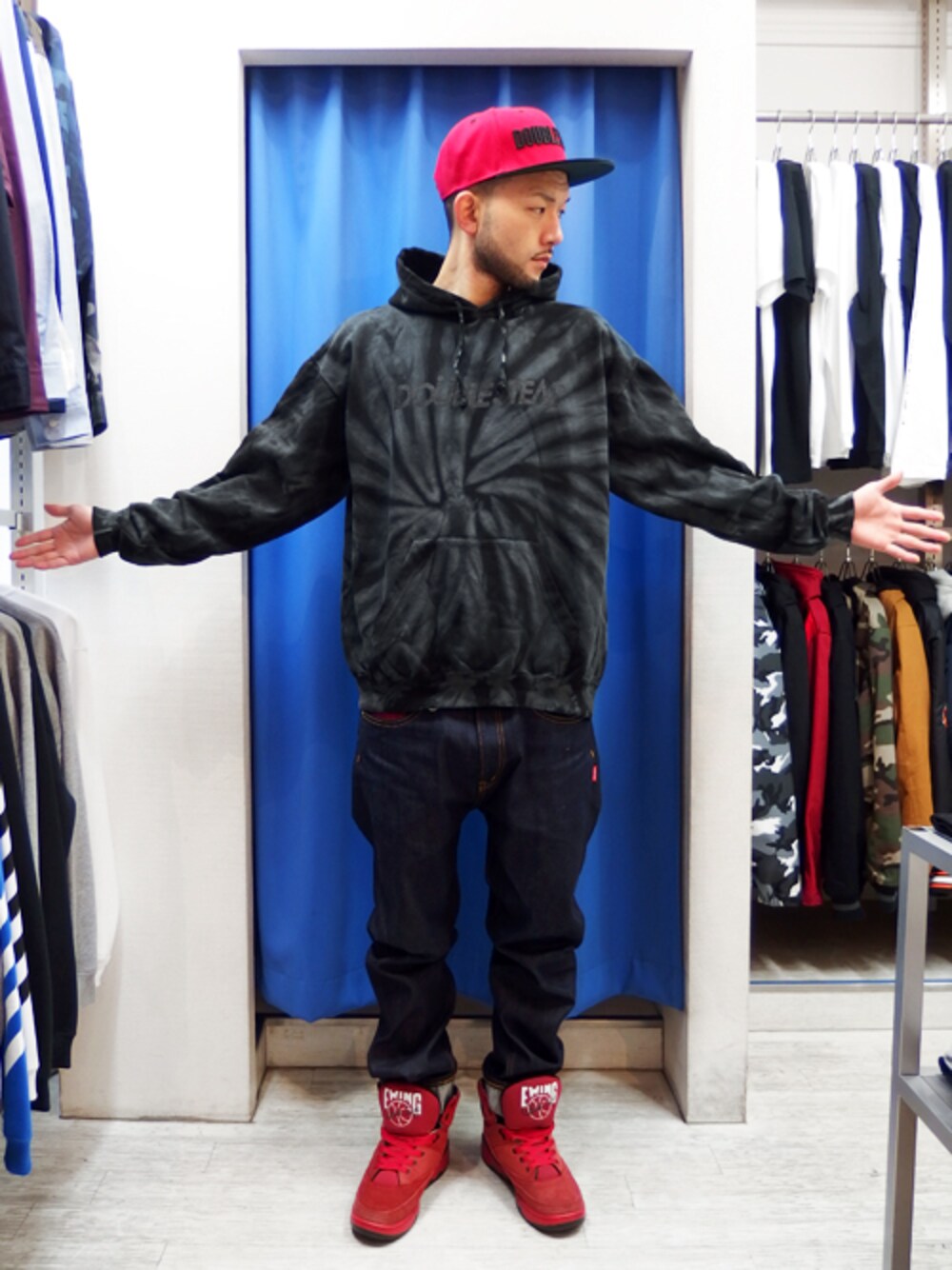 ブラック系のパーカー、その他のデニムパンツ、レッド系のキャップを着用したメンズの冬コーディネートの1枚目の写真
