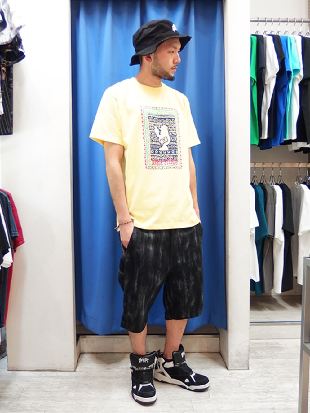 イエロー系のTシャツ/カットソー、ブラック系のチノパンツ、ブラック系のスニーカーを着用したメンズの春コーディネートの1枚目の写真