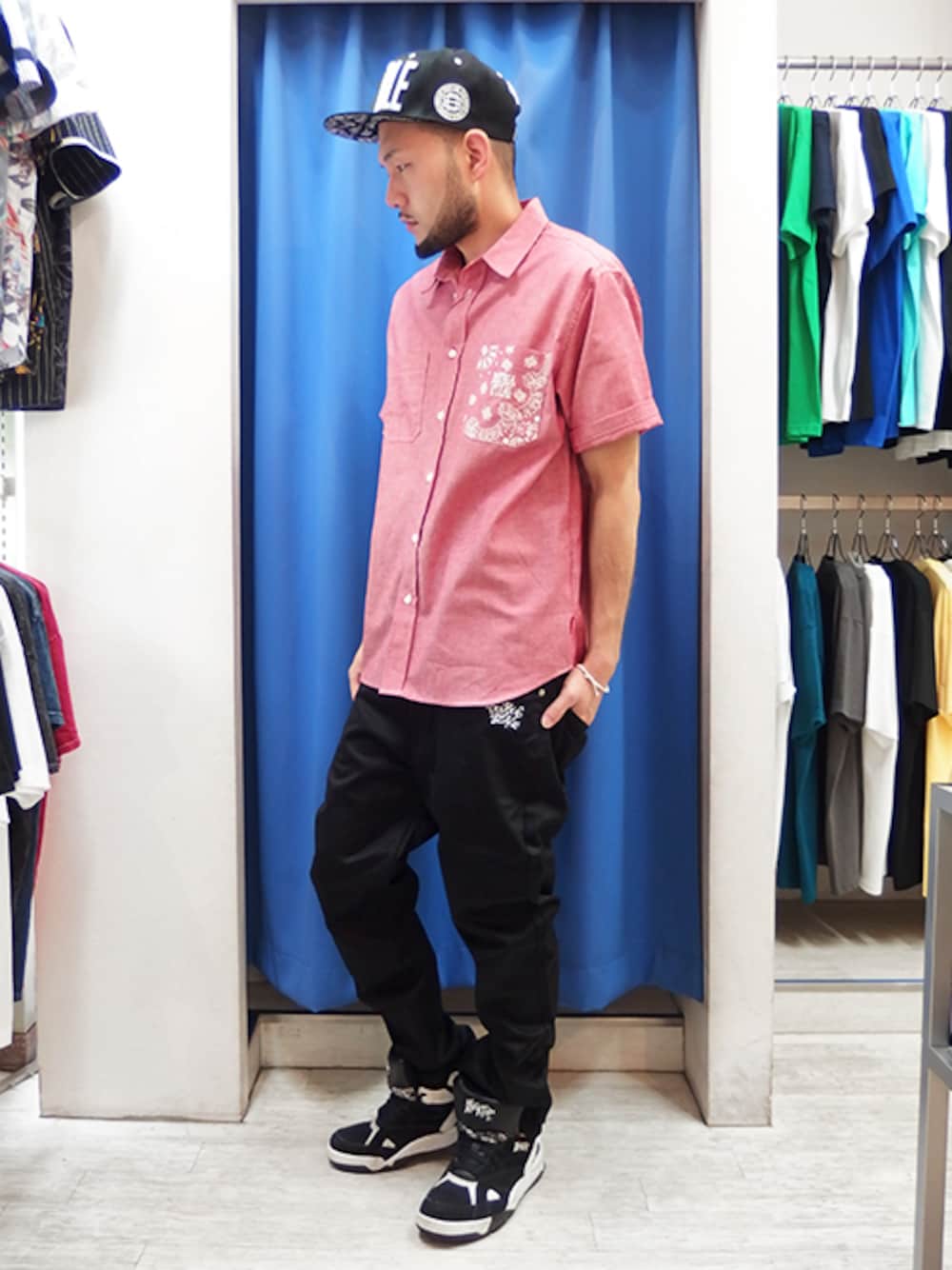 レッド系のシャツ/ブラウス、ブラック系のチノパンツ、ブラック系のスニーカーを着用したメンズの春コーディネートの1枚目の写真