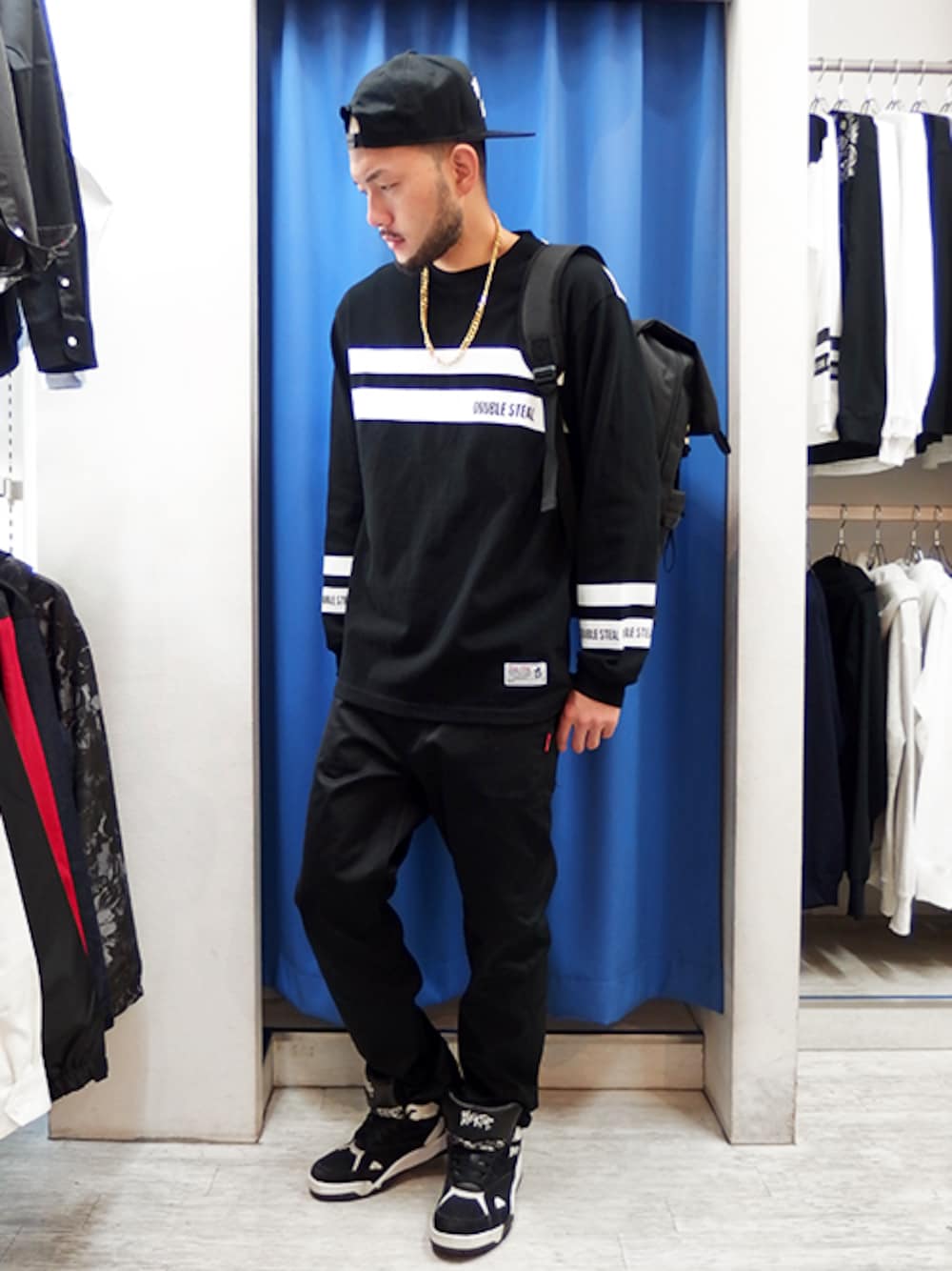 ブラック系のTシャツ/カットソー、ブラック系のチノパンツ、ブラック系のバックパック/リュックを着用したメンズの秋コーディネートの1枚目の写真