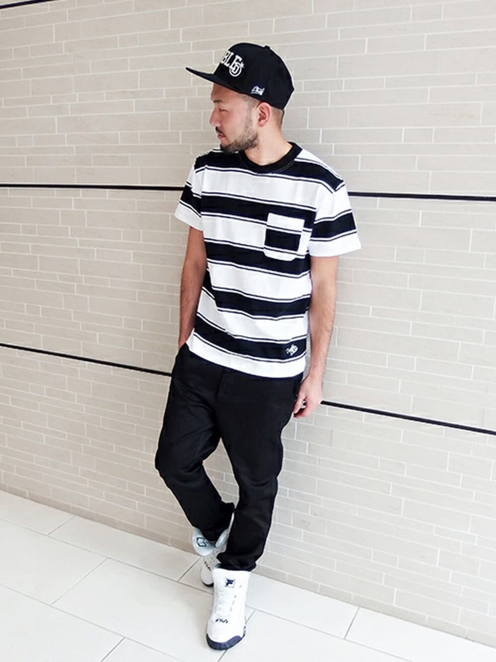 その他のTシャツ/カットソー、ブラック系のチノパンツ、ホワイト系のスニーカーを着用したメンズの冬コーディネートの1枚目の写真