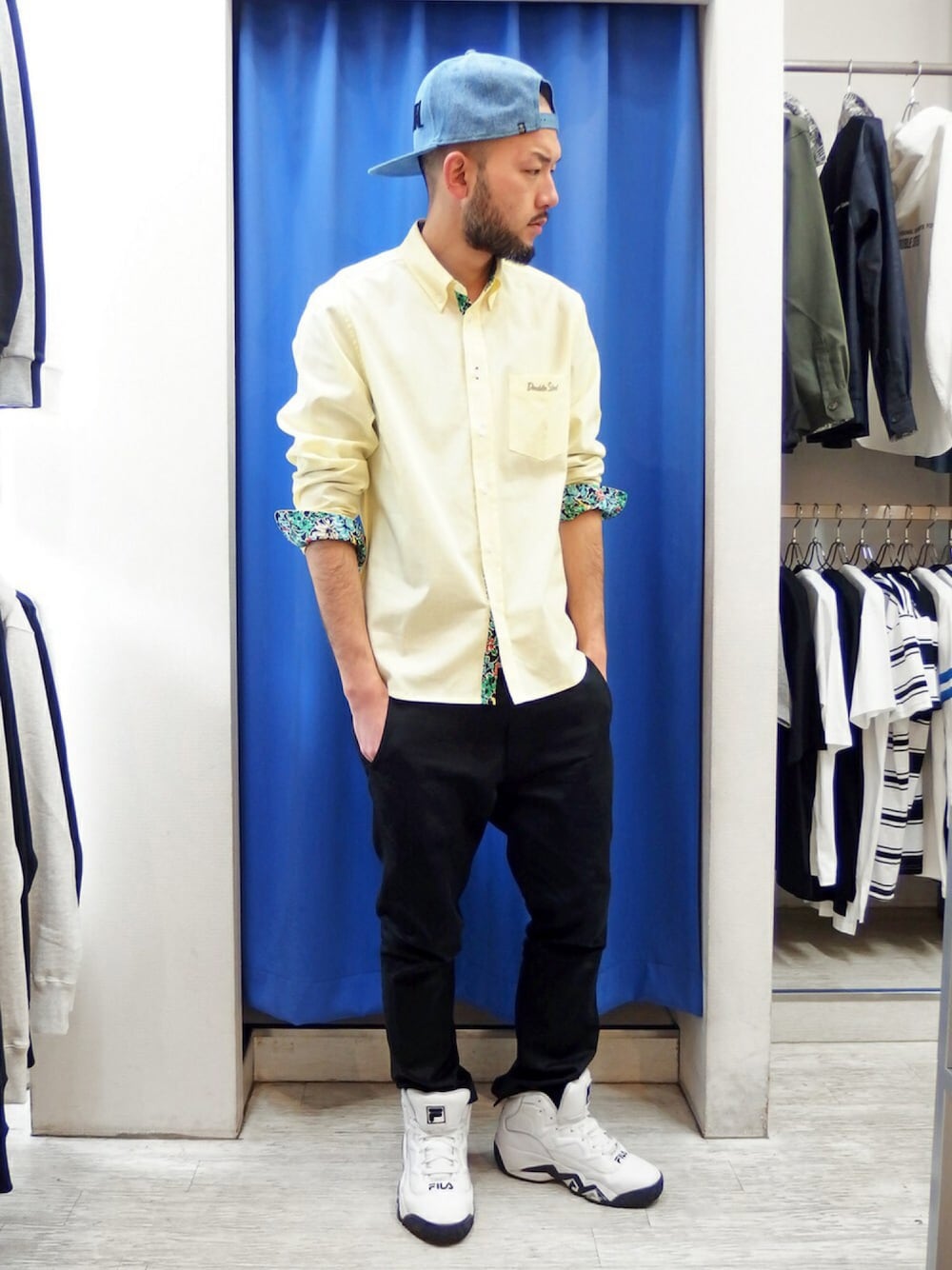 イエロー系のシャツ/ブラウス、ブラック系のチノパンツ、ホワイト系のスニーカーを着用したメンズの春コーディネートの1枚目の写真