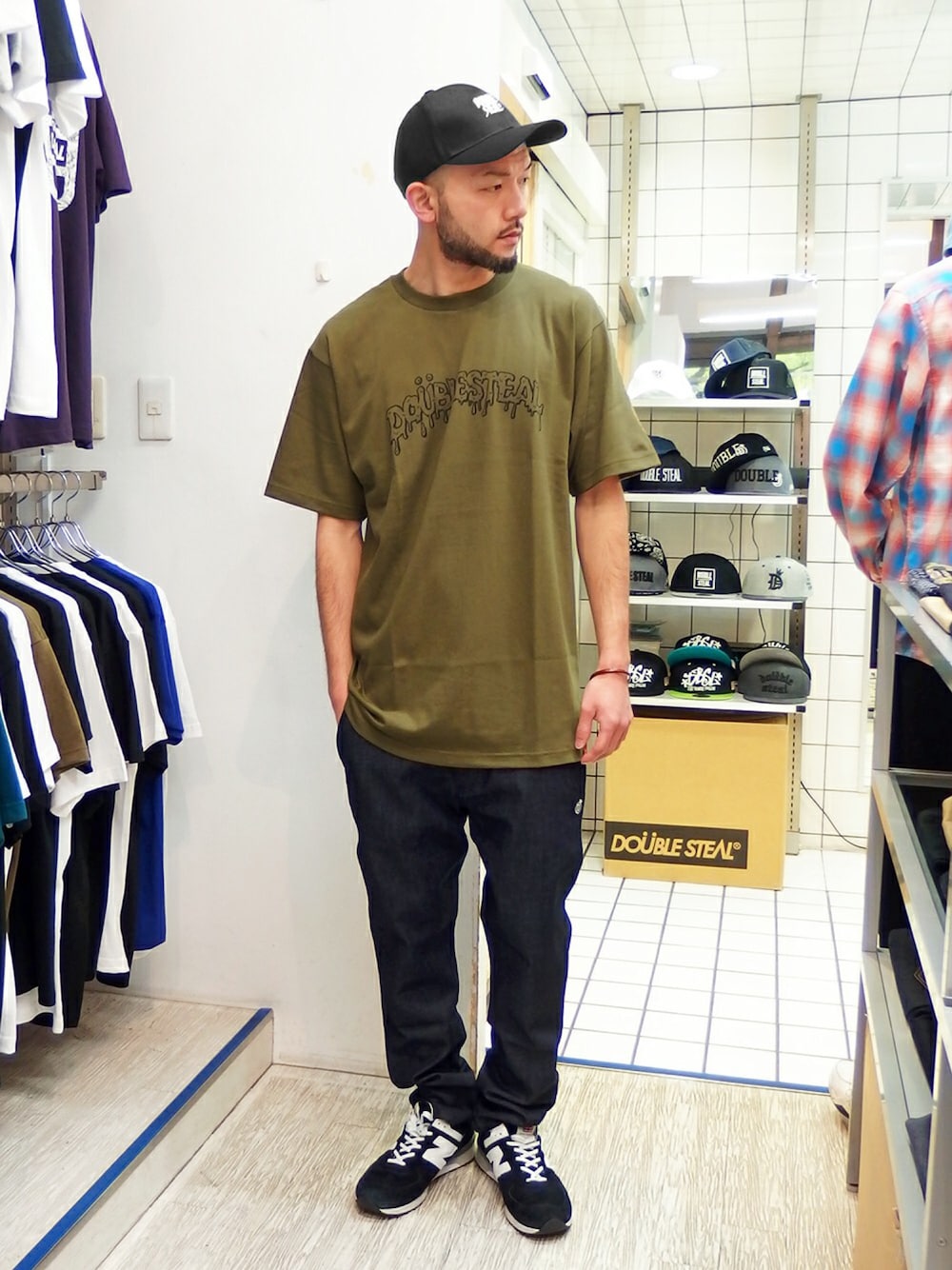 グリーン系のTシャツ/カットソー、その他のデニムパンツ、ブラック系のスニーカーを着用したメンズの春コーディネートの1枚目の写真