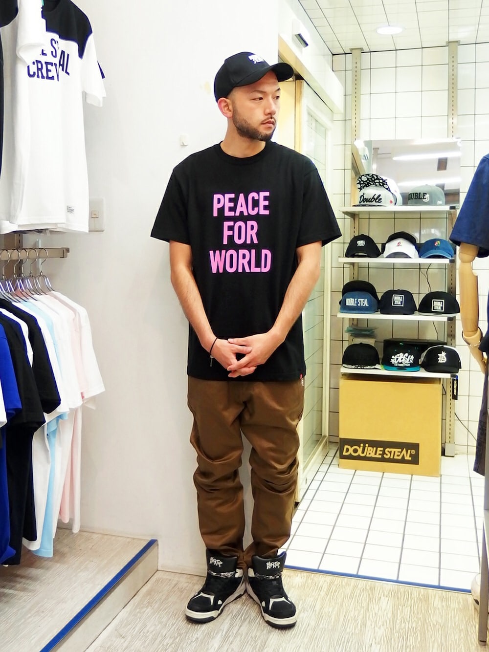 ブラック系のTシャツ/カットソー、ブラウン系のチノパンツ、ブラック系のスニーカーを着用したメンズの夏コーディネートの1枚目の写真
