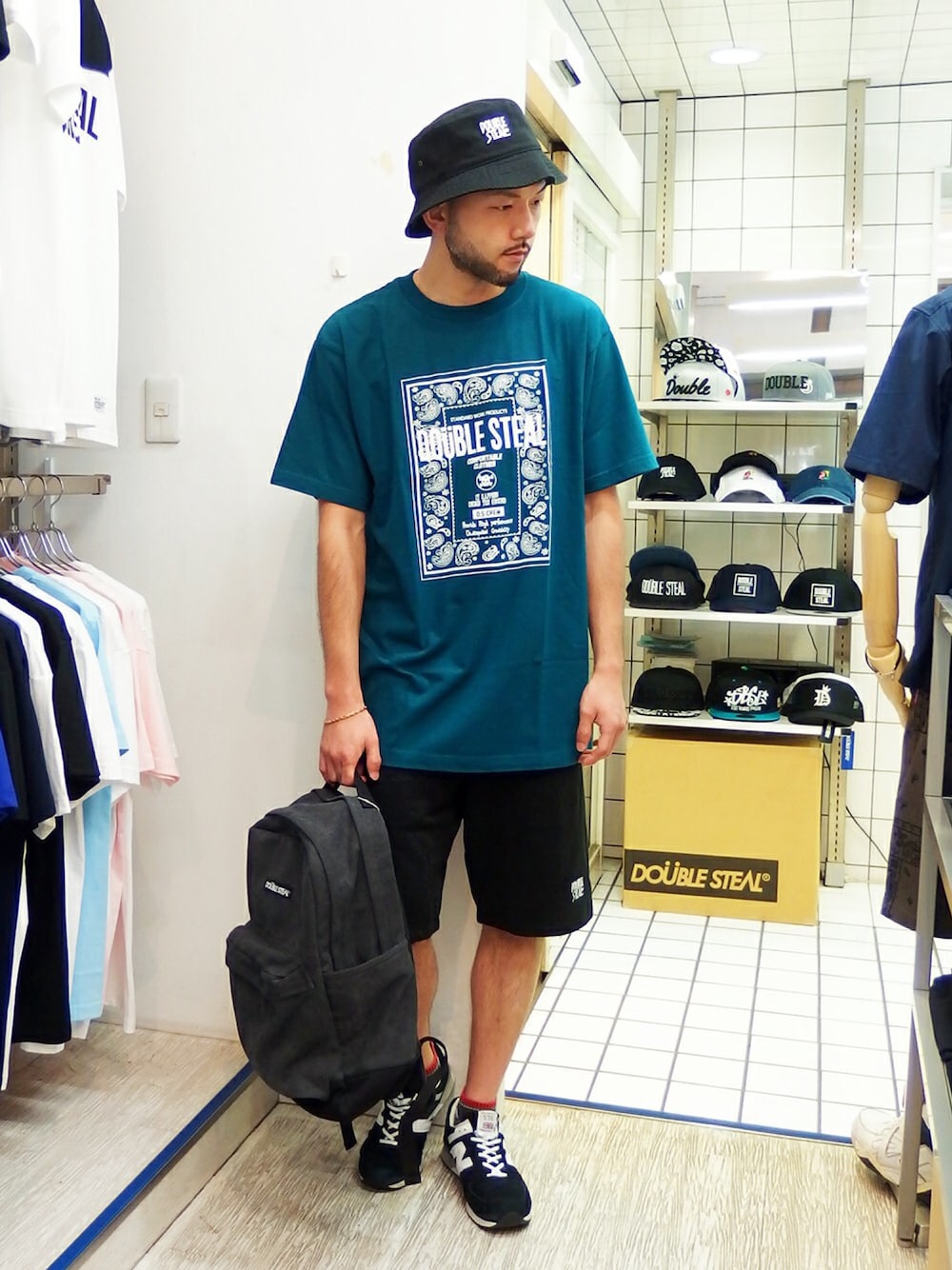 グリーン系のTシャツ/カットソー、ブラック系のその他パンツ、ブラック系のバックパック/リュックを着用したメンズの夏コーディネートの1枚目の写真