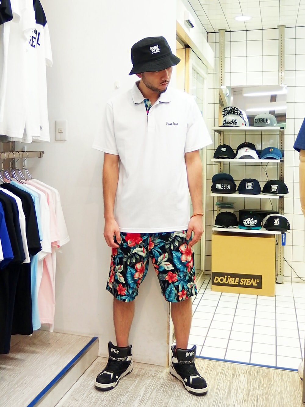 ホワイト系のポロシャツ、ブラック系のその他パンツ、ブラック系のスニーカーを着用したメンズの夏コーディネートの1枚目の写真