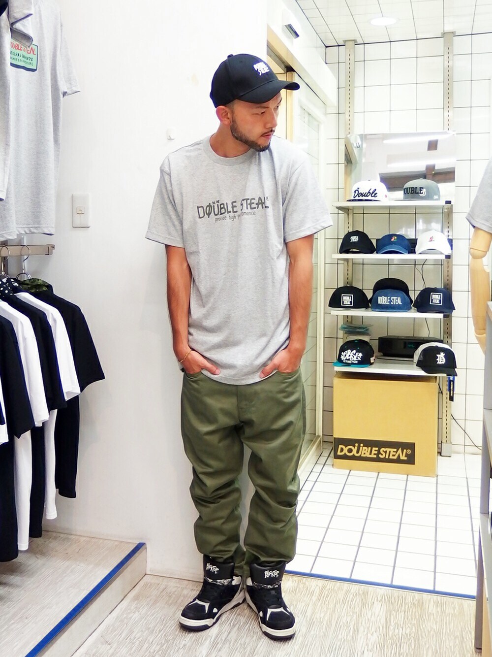 グレー系のTシャツ/カットソー、グリーン系のチノパンツ、ブラック系のスニーカーを着用したメンズの夏コーディネートの1枚目の写真