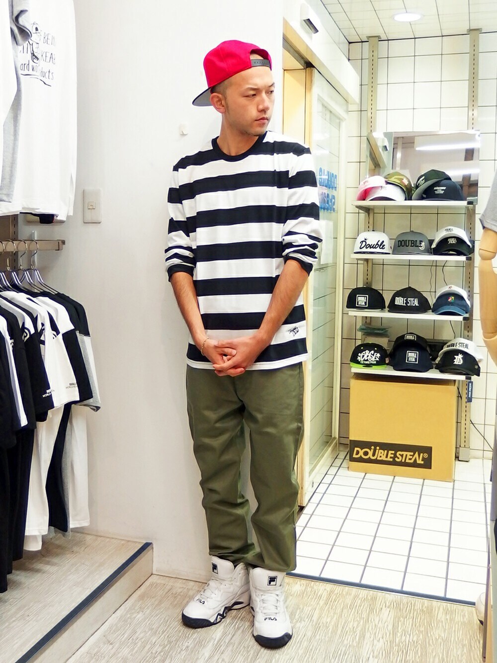ホワイト系のTシャツ/カットソー、グリーン系のチノパンツ、ホワイト系のスニーカーを着用したメンズの秋コーディネートの1枚目の写真