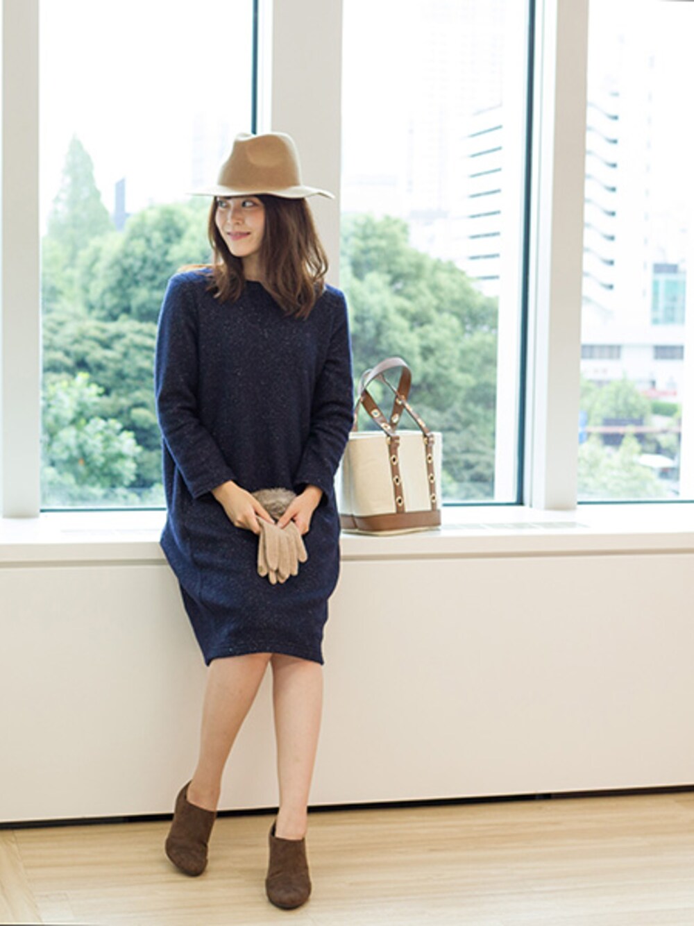 ブルー系のワンピース、ブラック系のブーティ、ブラック系のハットを着用したレディースの秋コーディネートの1枚目の写真