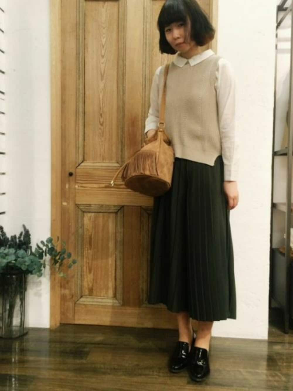 ベージュ系のベスト、ホワイト系のシャツ/ブラウス、グリーン系のその他パンツを着用したレディースの春コーディネートの1枚目の写真