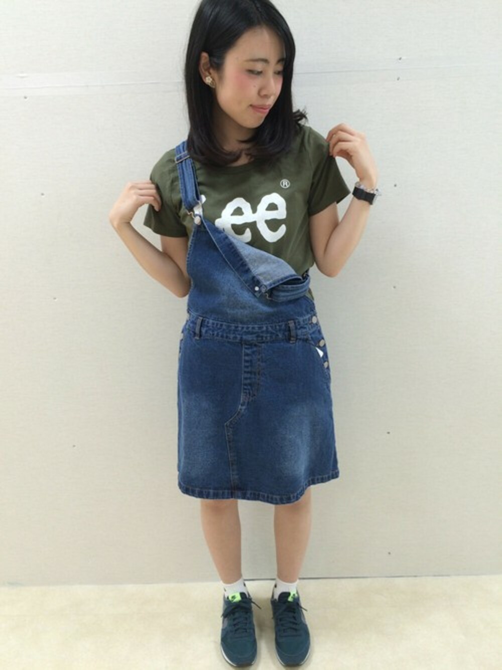 グリーン系のTシャツ/カットソー、ブルー系のジャンパースカートを着用したレディースの春コーディネートの1枚目の写真