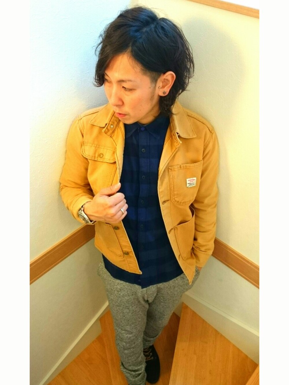 ブラウン系のカバーオール、グレー系のその他パンツ、ブラック系のブーツを着用したメンズの冬コーディネートの1枚目の写真