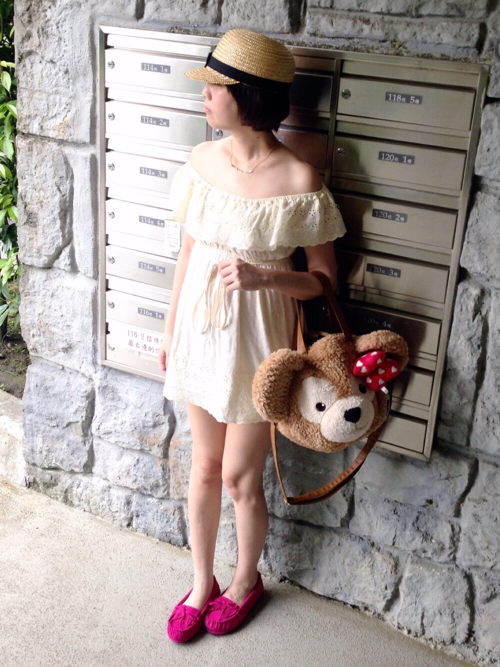 ベージュ系のクラッチバッグ、ベージュ系のチュニック、ピンク系のモカシン/デッキシューズを着用したレディースの夏コーディネートの1枚目の写真