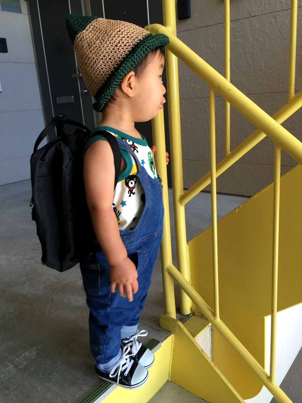 ホワイト系のタンクトップ、ブルー系のサロペット/オーバーオール、ブラック系のバックパック/リュックを着用したキッズの夏コーディネートの1枚目の写真