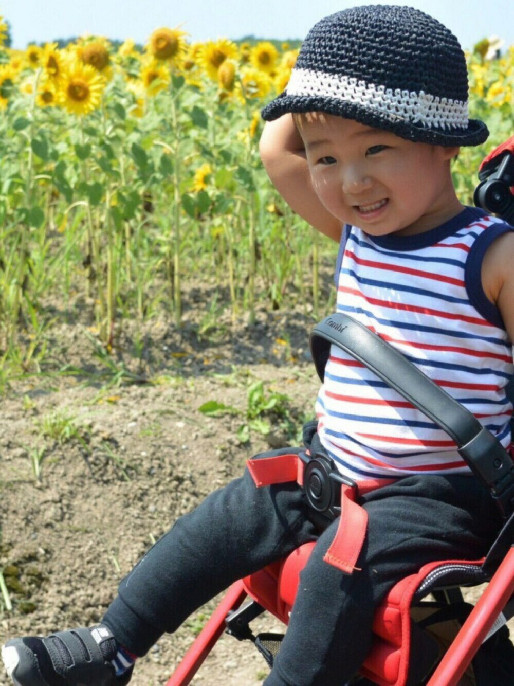 レッド系のタンクトップ、ブラック系のその他パンツ、ブラック系のスニーカーを着用したキッズの夏コーディネートの1枚目の写真