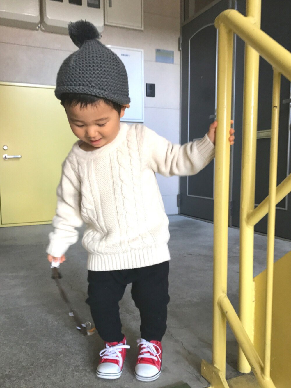 ホワイト系のニット/セーター、ブラック系のスウェットパンツ、レッド系のスニーカーを着用したキッズの秋コーディネートの1枚目の写真