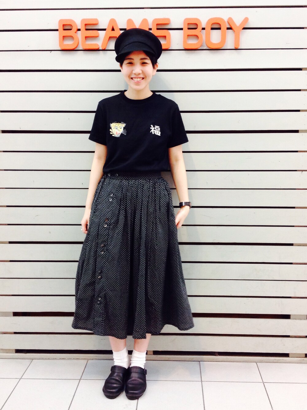 ブラック系のTシャツ/カットソー、ブラック系のスカート、ブラック系のキャスケットを着用したレディースの春コーディネートの1枚目の写真