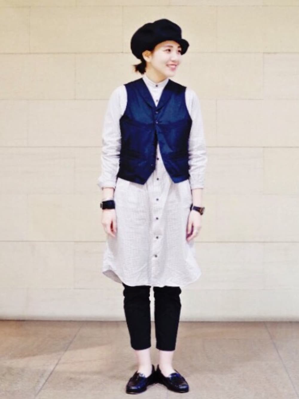 ブルー系のベスト、ブルー系のスラックス、ブラック系のドレスシューズを着用したレディースの冬コーディネートの1枚目の写真