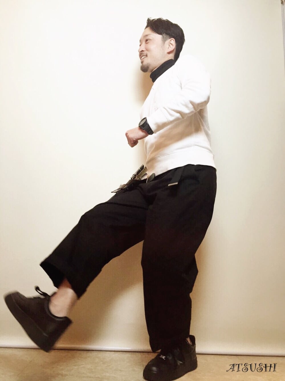 ブラック系のパンツ、ブラック系のスニーカー、ホワイト系のスウェットを着用したメンズの冬コーディネートの1枚目の写真