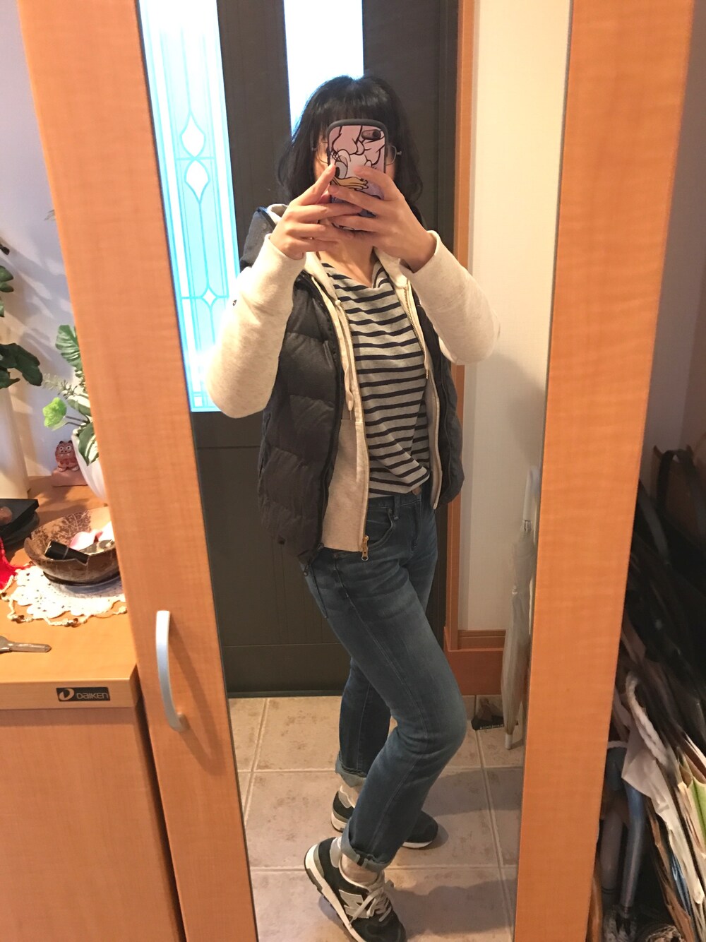 グレー系のTシャツ/カットソー、ベージュ系のパーカー、グレー系のダウンベストを着用したレディースの秋コーディネートの1枚目の写真