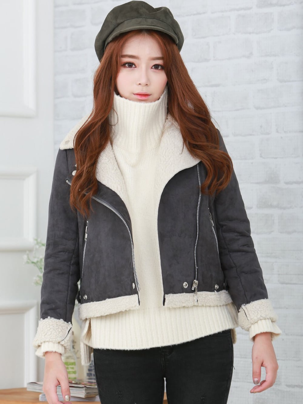 ホワイト系のニット/セーター、ブラック系のライダースジャケット、グリーン系のキャスケットを着用したレディースの秋コーディネートの1枚目の写真