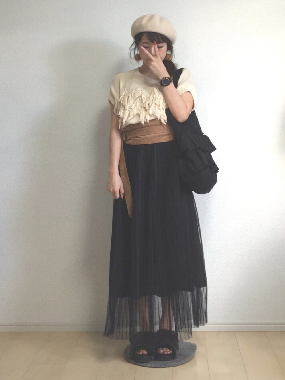 ベージュ系のニット/セーター、ブラック系のスカート、グレー系のサンダルを着用したレディースの秋コーディネートの1枚目の写真