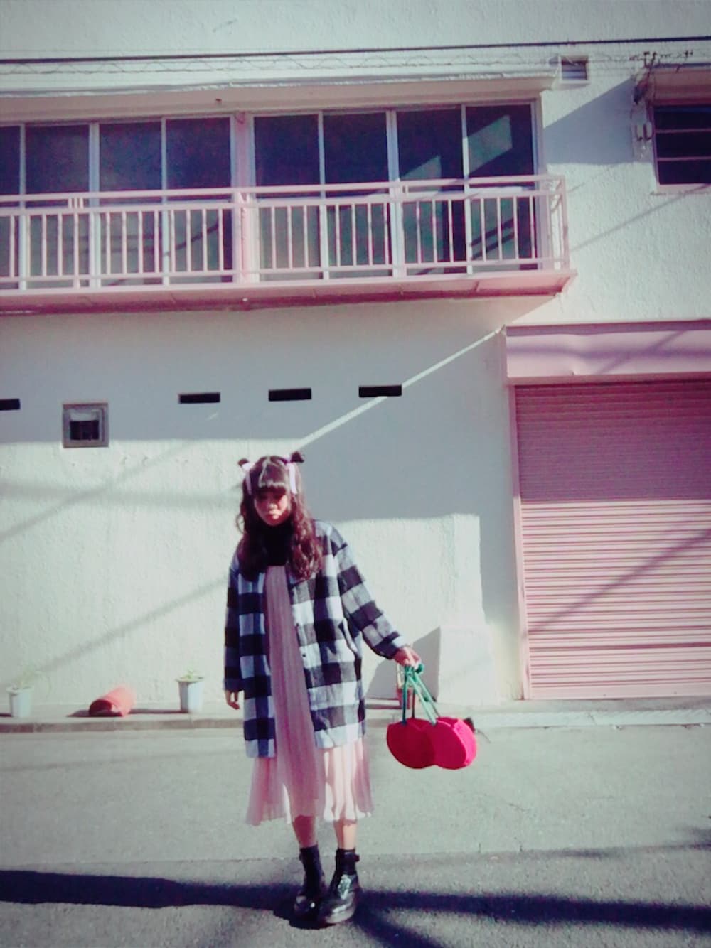 ブラック系のワンピース、ピンク系のワンピース、レッド系のハンドバッグを着用したレディースの冬コーディネートの1枚目の写真