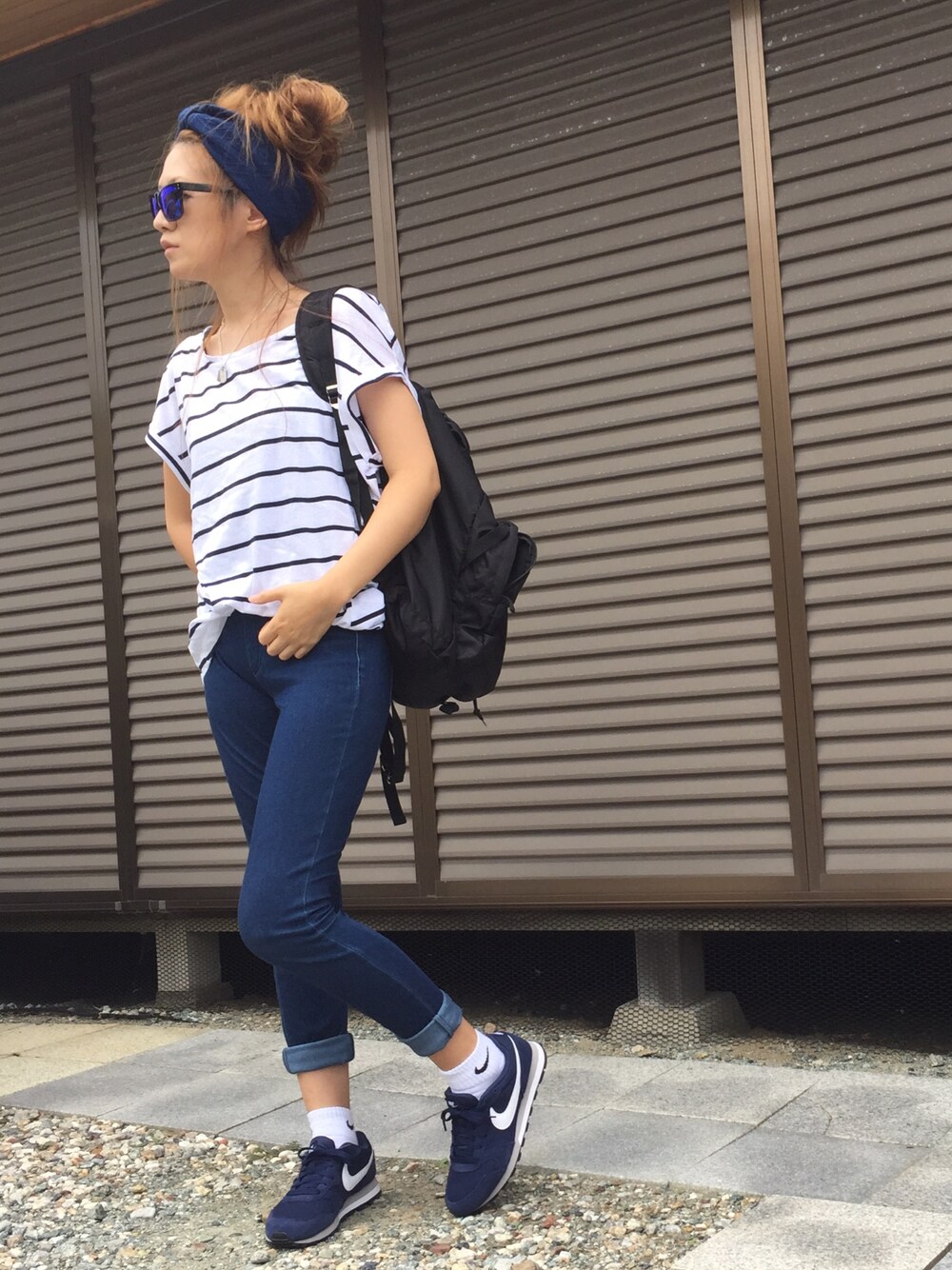 ブラック系のバックパック/リュック、ホワイト系のTシャツ/カットソー、ブルー系のスニーカーを着用したレディースの夏コーディネートの1枚目の写真