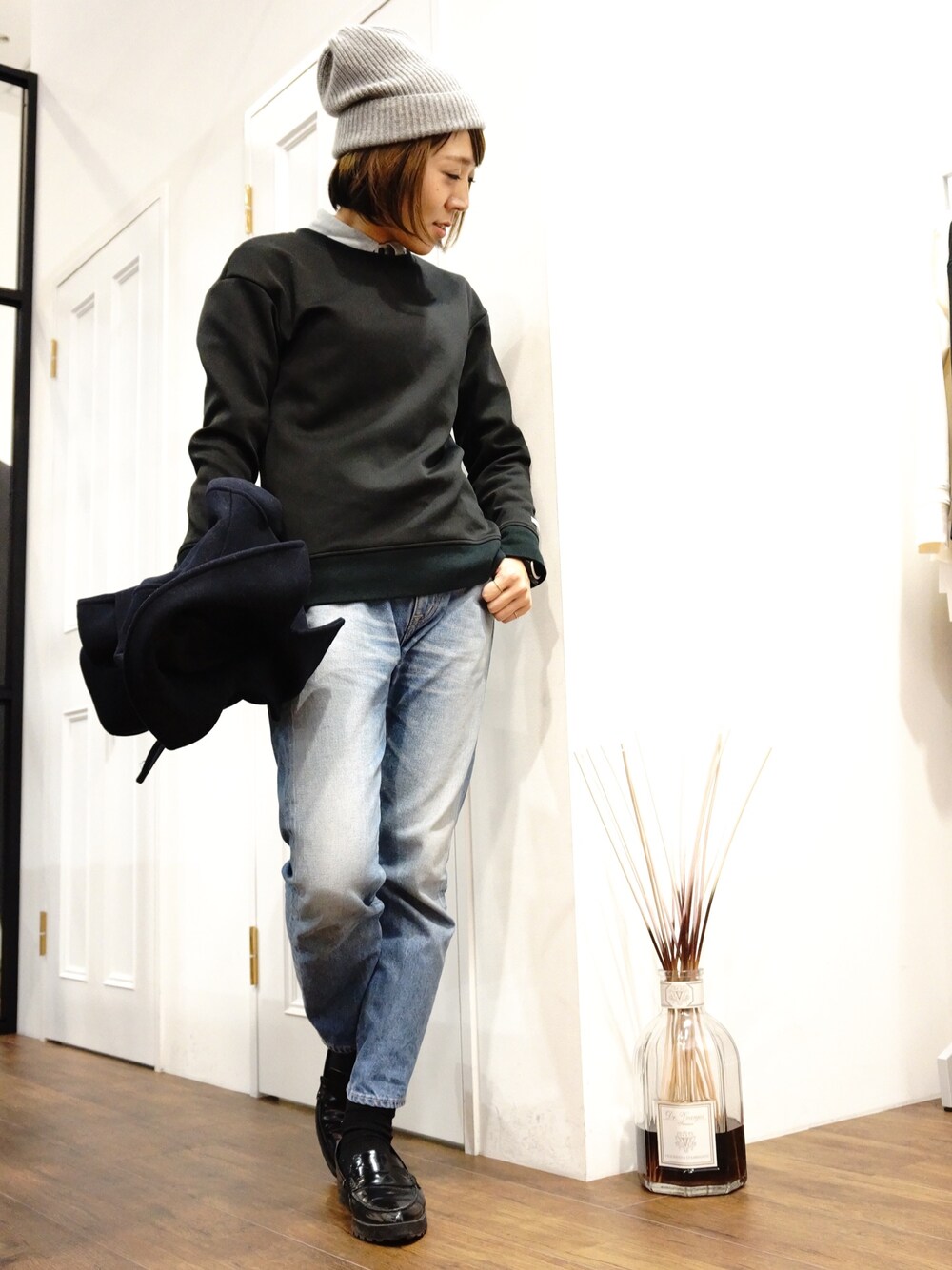 ホワイト系のニット/セーター、ブルー系のシャツ/ブラウス、ブルー系のデニムパンツを着用したレディースの冬コーディネートの1枚目の写真