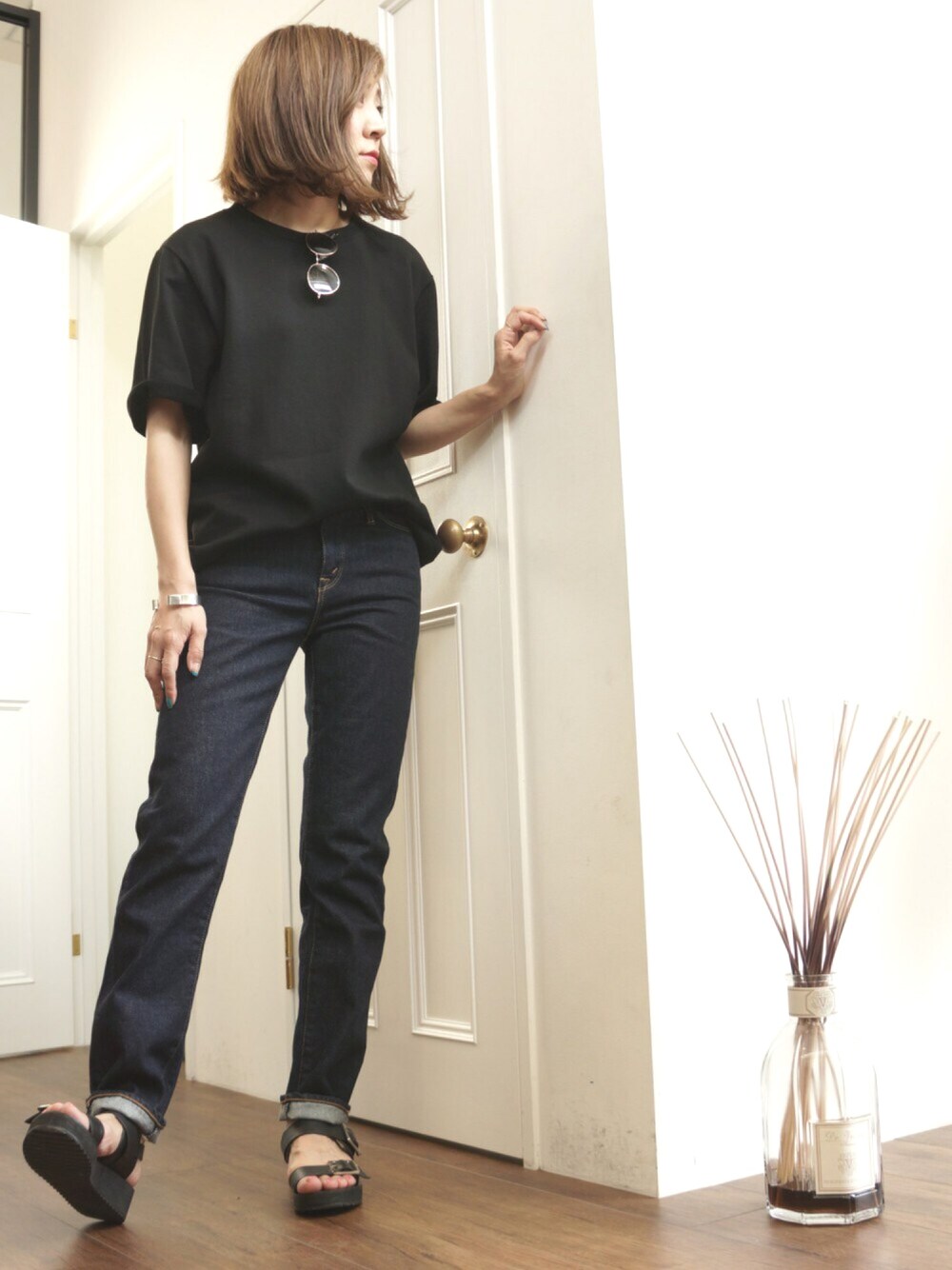 ブラック系のTシャツ/カットソー、ブルー系のデニムパンツ、パープル系の香水を着用したレディースの春コーディネートの1枚目の写真