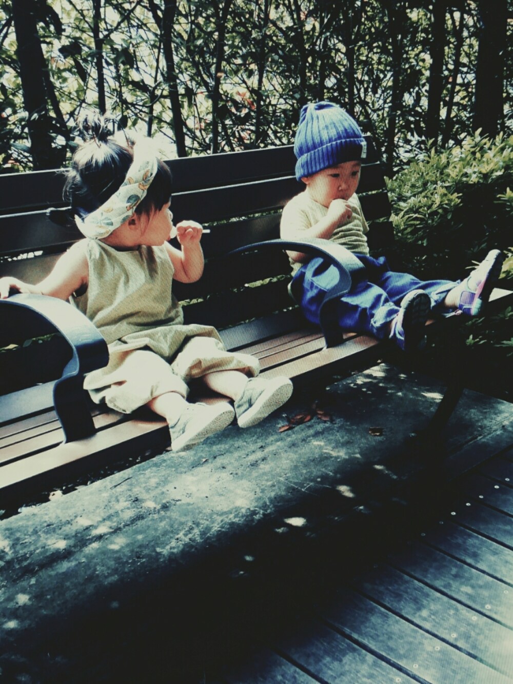 イエロー系のオールインワン・サロペット、グリーン系のスニーカー、ブルー系のパンツを着用したキッズの夏コーディネートの1枚目の写真