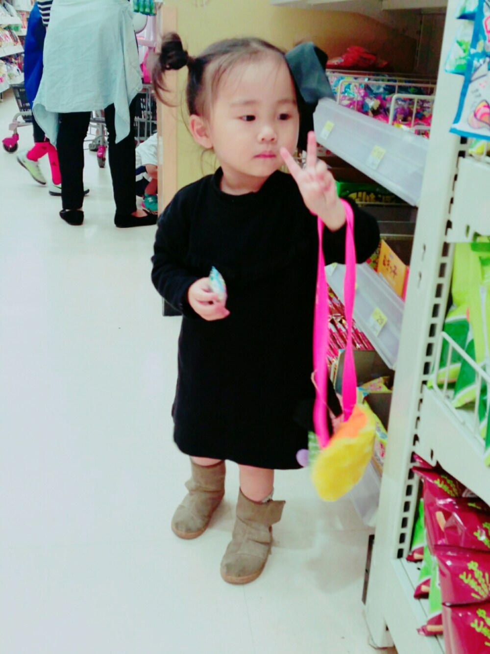 ブラック系のワンピース、ベージュ系のブーツを着用したキッズの秋コーディネートの1枚目の写真