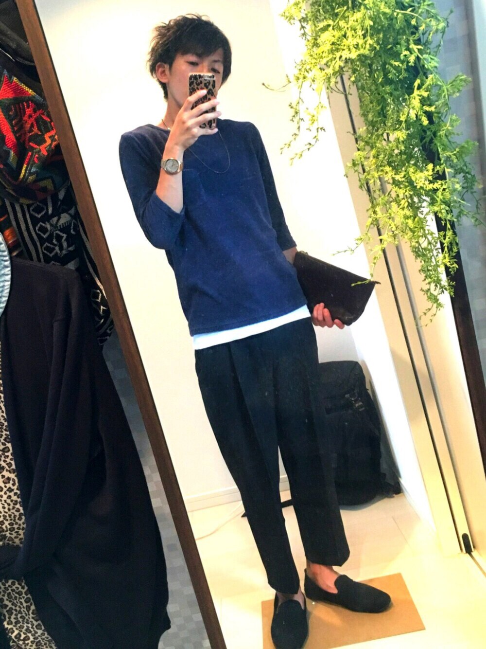 ブルー系のニット/セーター、ホワイト系のタンクトップ、ブラウン系のクラッチバッグを着用したメンズの夏コーディネートの1枚目の写真