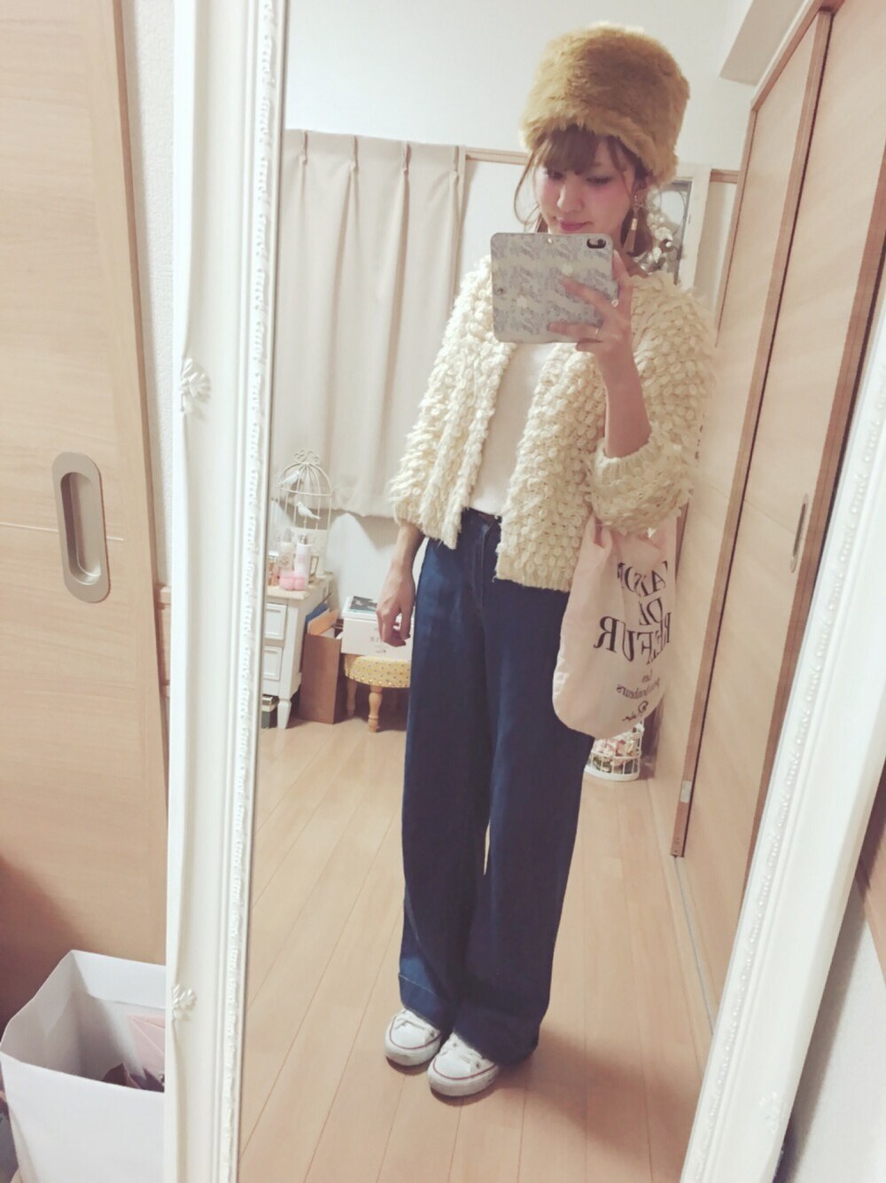 ブルー系のデニムパンツ、ホワイト系のスニーカー、ホワイト系のカーディガン/ボレロを着用したレディースの冬コーディネートの1枚目の写真