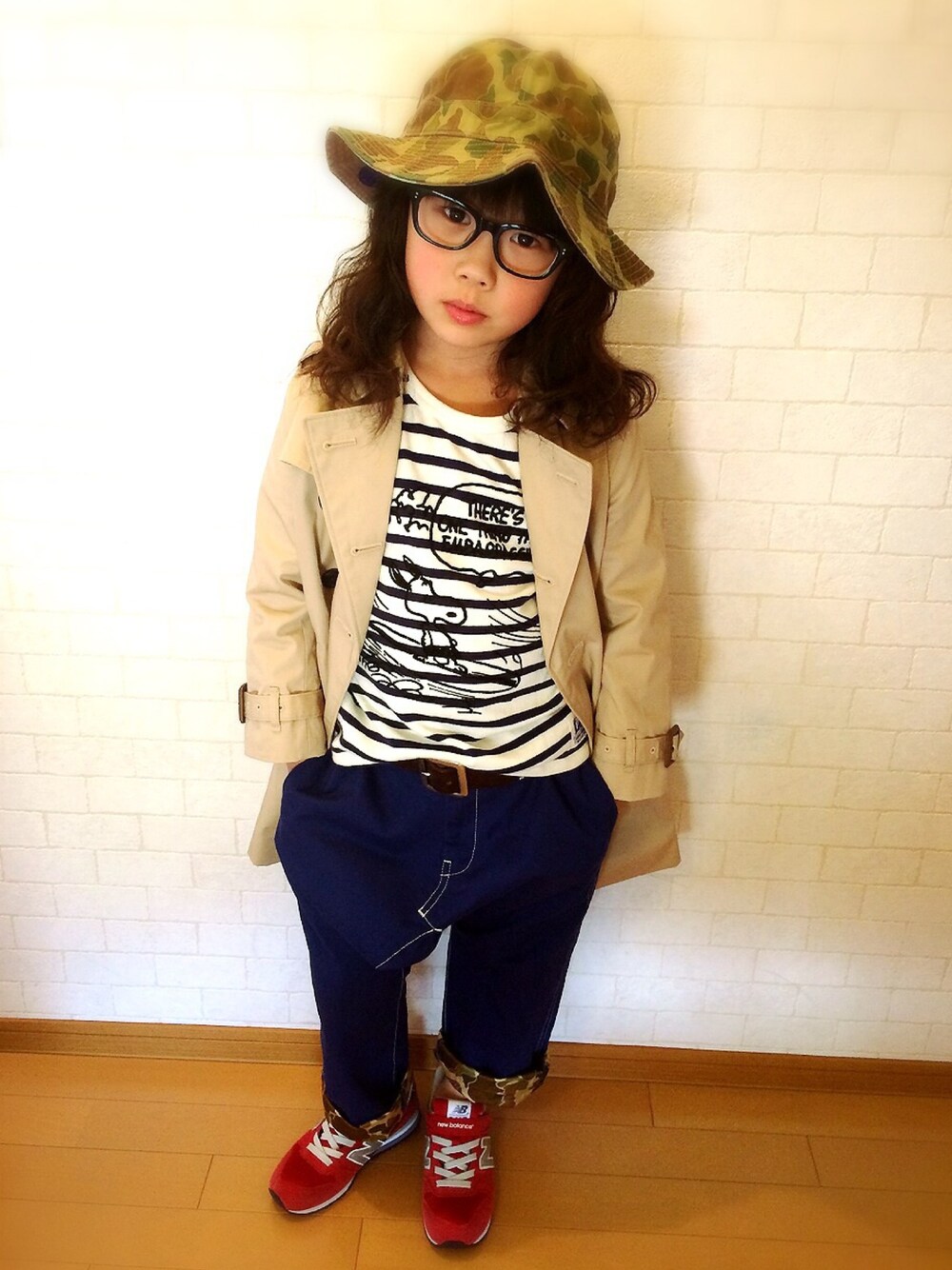 ベージュ系のトレンチコート、ホワイト系のTシャツ/カットソー、レッド系のスニーカーを着用したキッズの春コーディネートの1枚目の写真