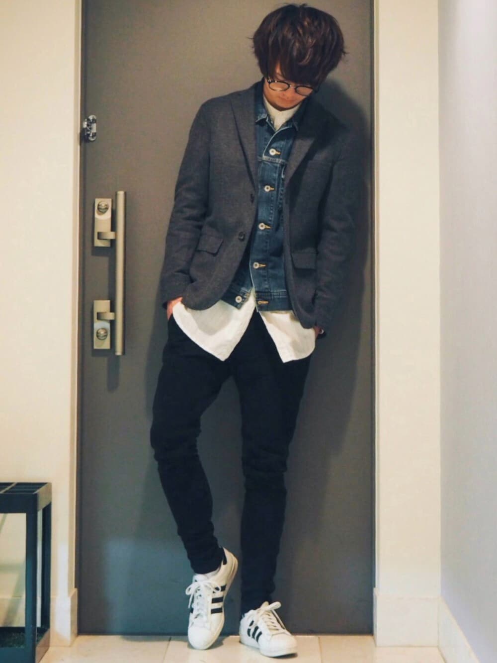 グレー系のテーラードジャケット、ブルー系のデニムジャケット、ホワイト系のスニーカーを着用したメンズの冬コーディネートの1枚目の写真