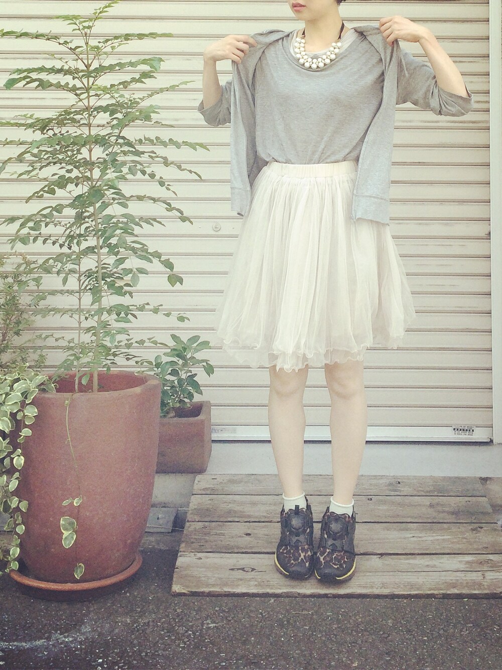 ブラウン系のスニーカー、グレー系のピアス(両耳用)、ゴールド系のネックレスを着用したレディースの秋コーディネートの1枚目の写真