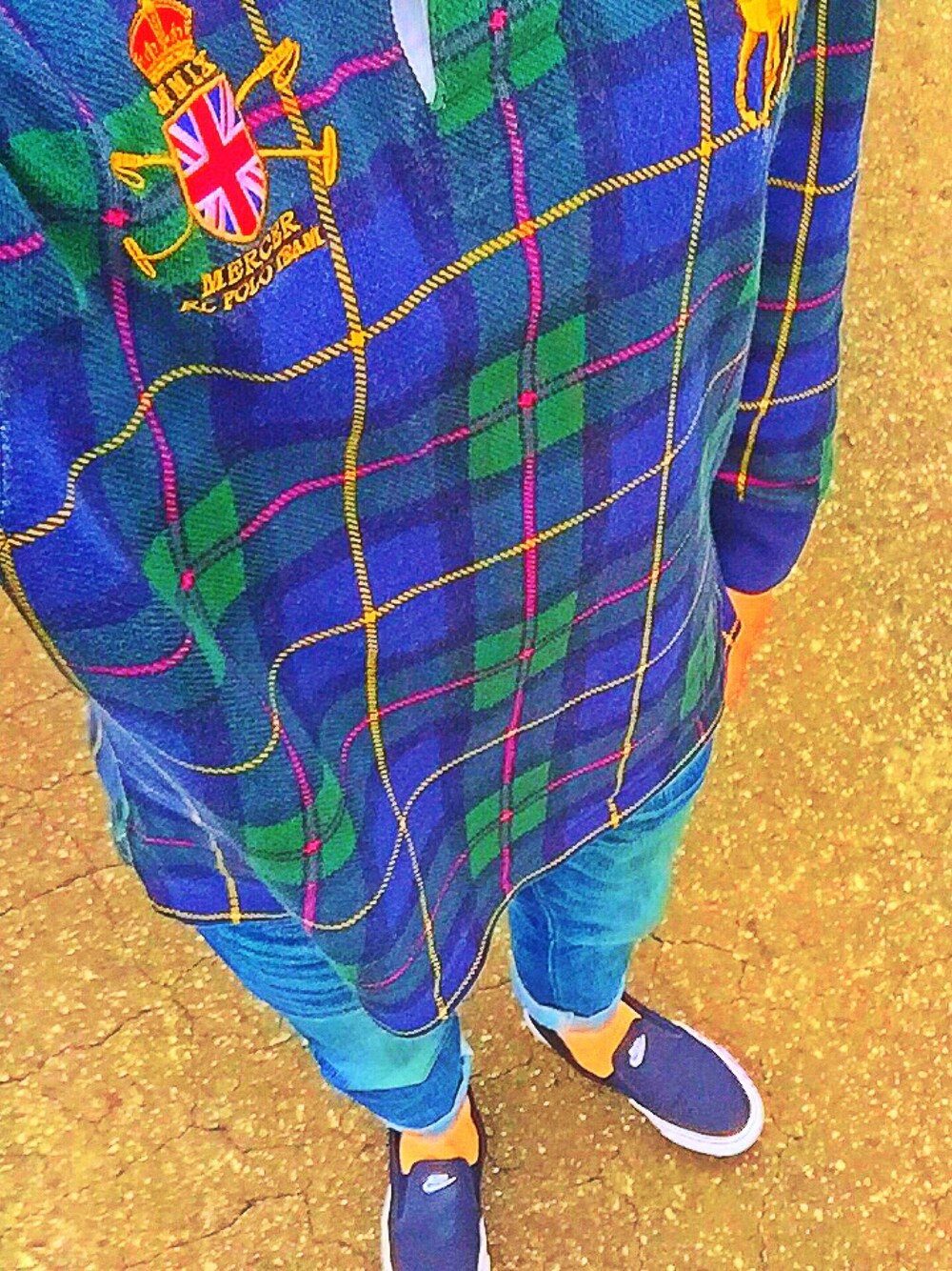 グリーン系のポロシャツ、ブルー系のデニムパンツ、ブラック系のシューズを着用したメンズの秋コーディネートの1枚目の写真