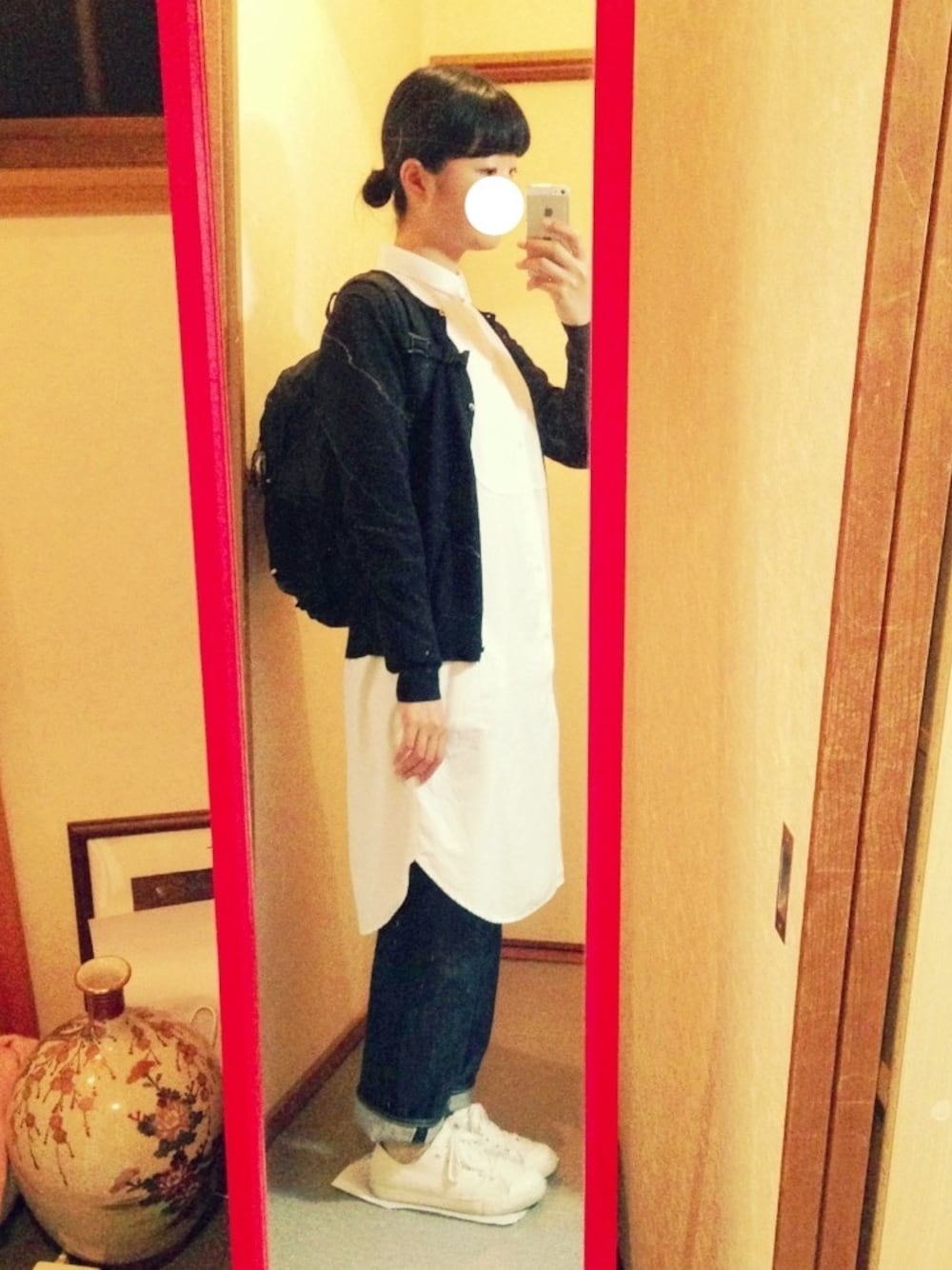 ブラック系のカーディガン/ボレロ、ホワイト系のシャツワンピース、ブルー系のデニムパンツを着用したレディースの春コーディネートの1枚目の写真