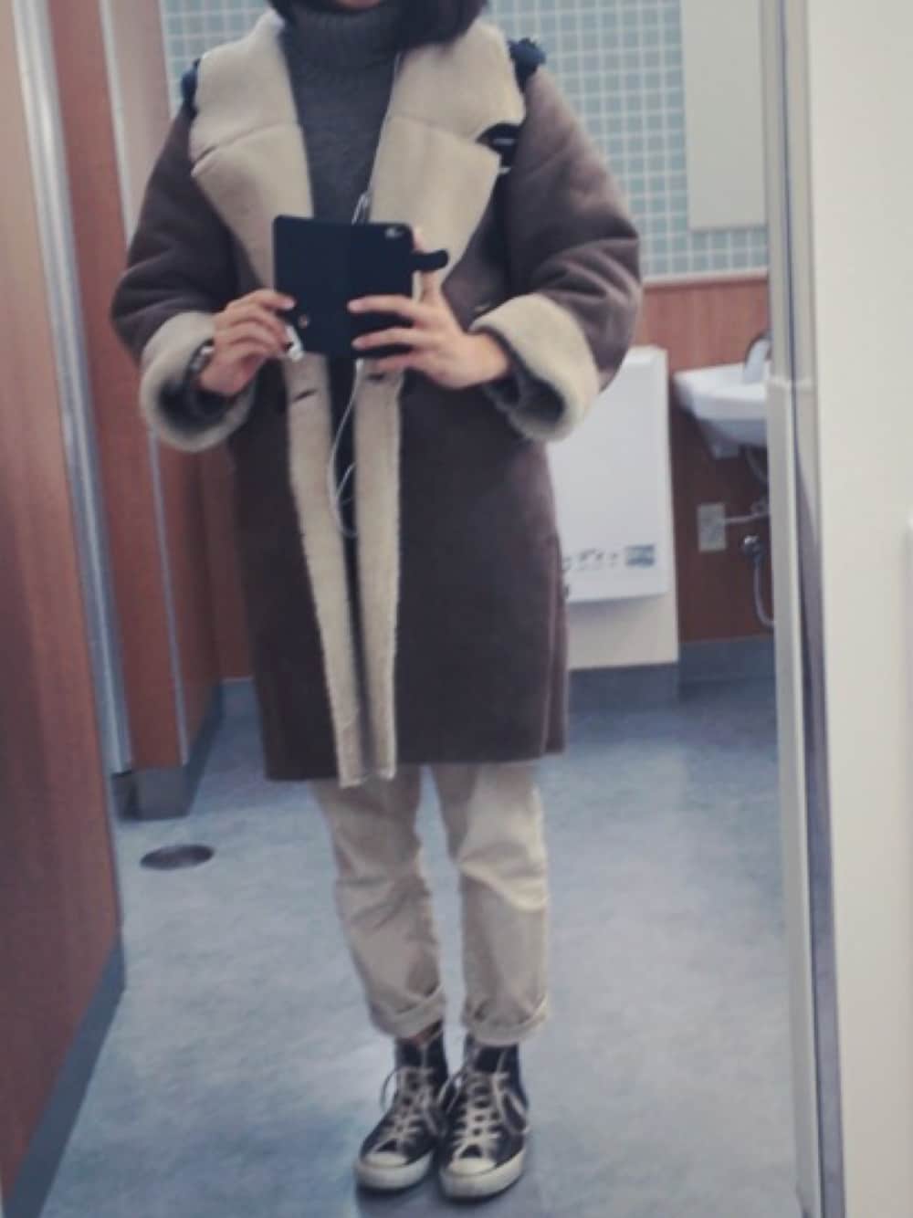 ホワイト系のパンツ、ベージュ系のスニーカー、ブラウン系のニット/セーターを着用したレディースの冬コーディネートの1枚目の写真