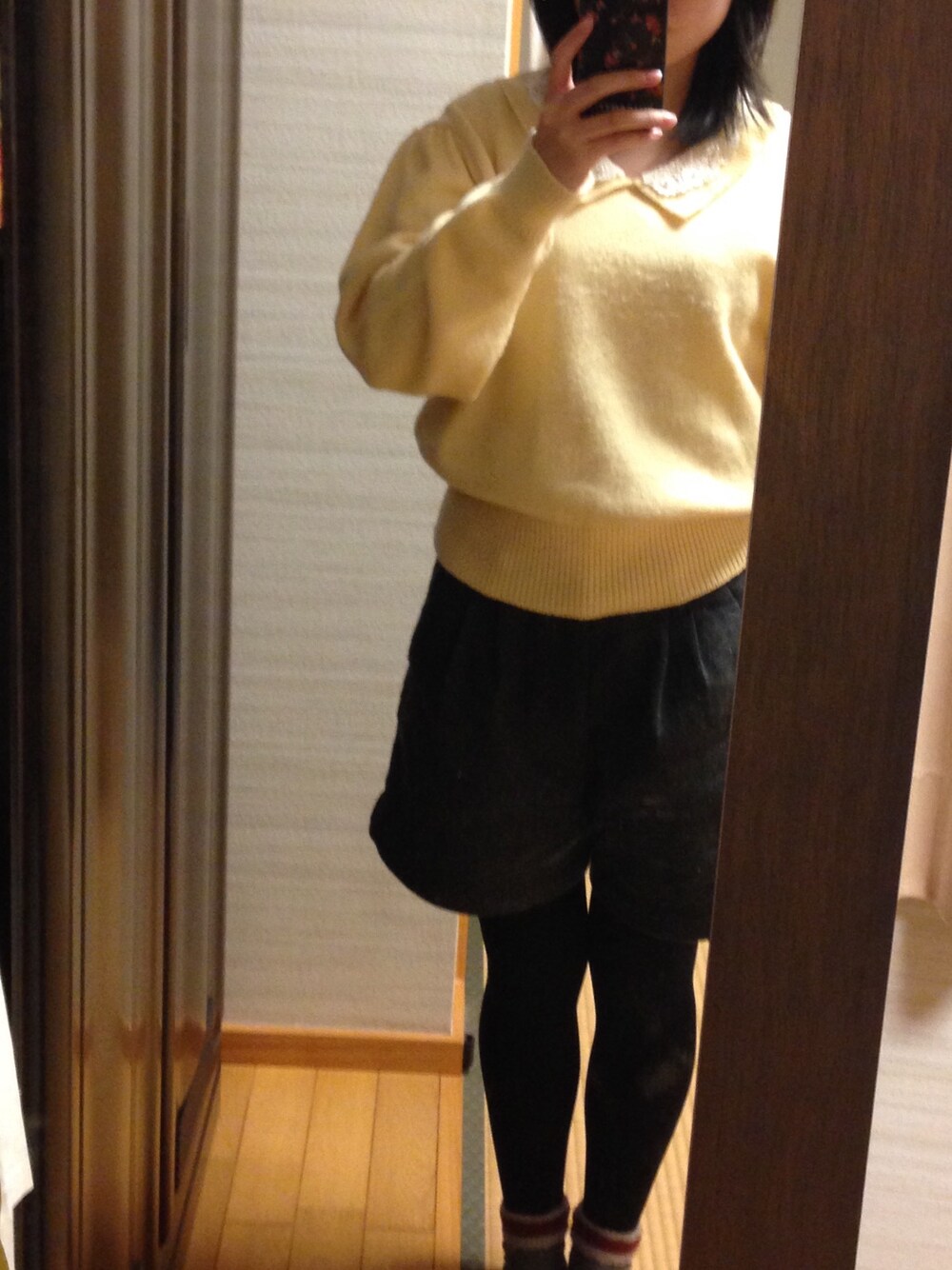 イエロー系のニット/セーター、グレー系のその他パンツ、ブラック系のタイツ/ストッキングを着用したレディースの冬コーディネートの1枚目の写真