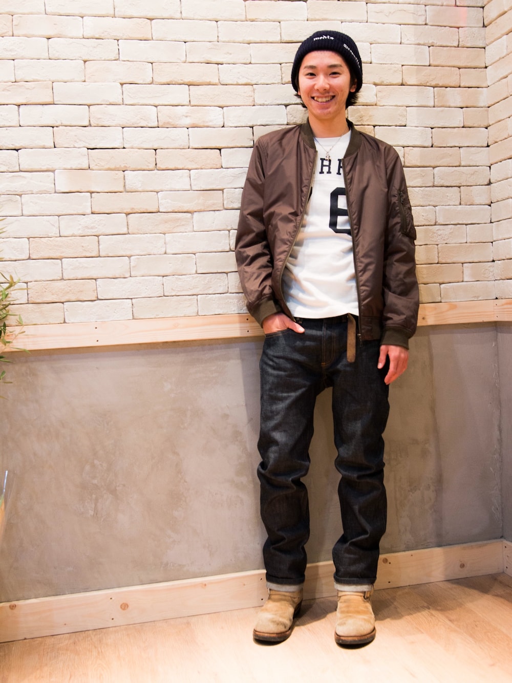 ホワイト系のTシャツ/カットソー、グリーン系のミリタリージャケット、ブルー系のデニムパンツを着用したメンズの冬コーディネートの1枚目の写真