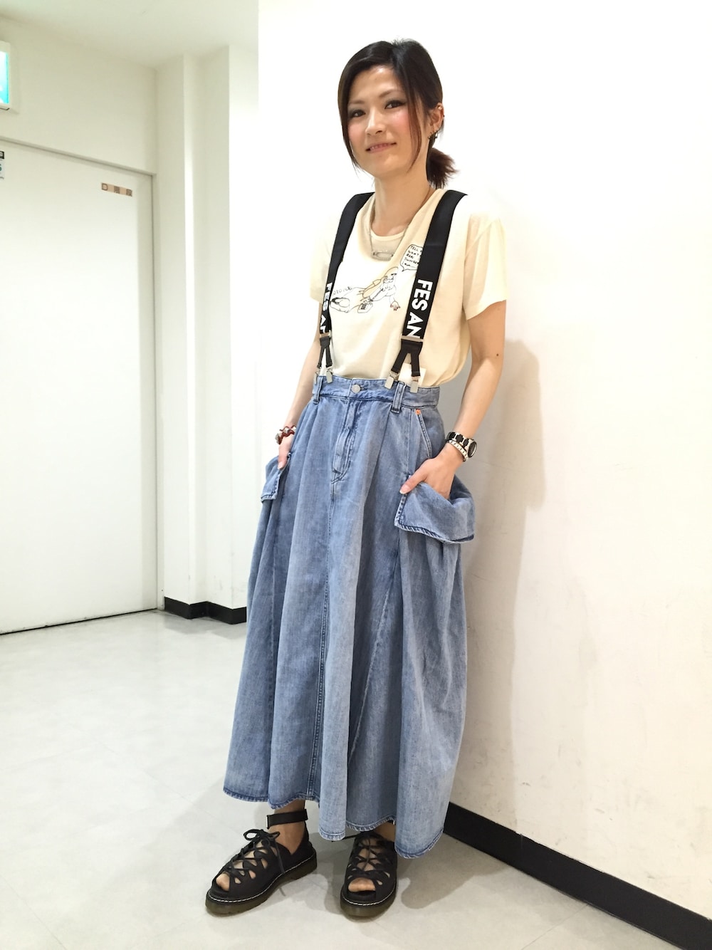 ブルー系のデニムスカート、ホワイト系のTシャツ/カットソー、ブラック系のサンダルを着用したレディースの春コーディネートの1枚目の写真