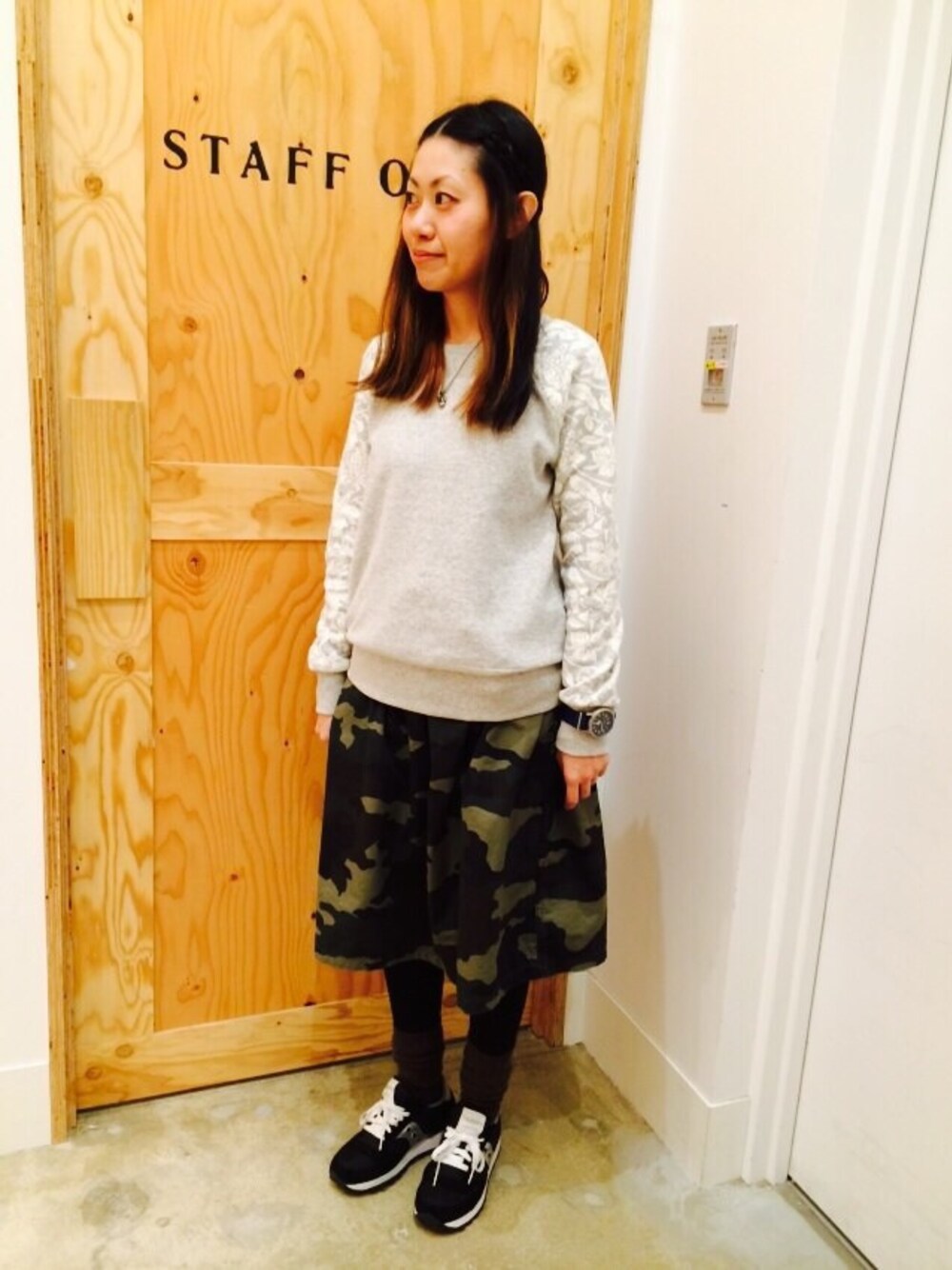 グレー系のスウェット、グリーン系のスカート、ブルー系のアナログ腕時計を着用したレディースの春コーディネートの1枚目の写真