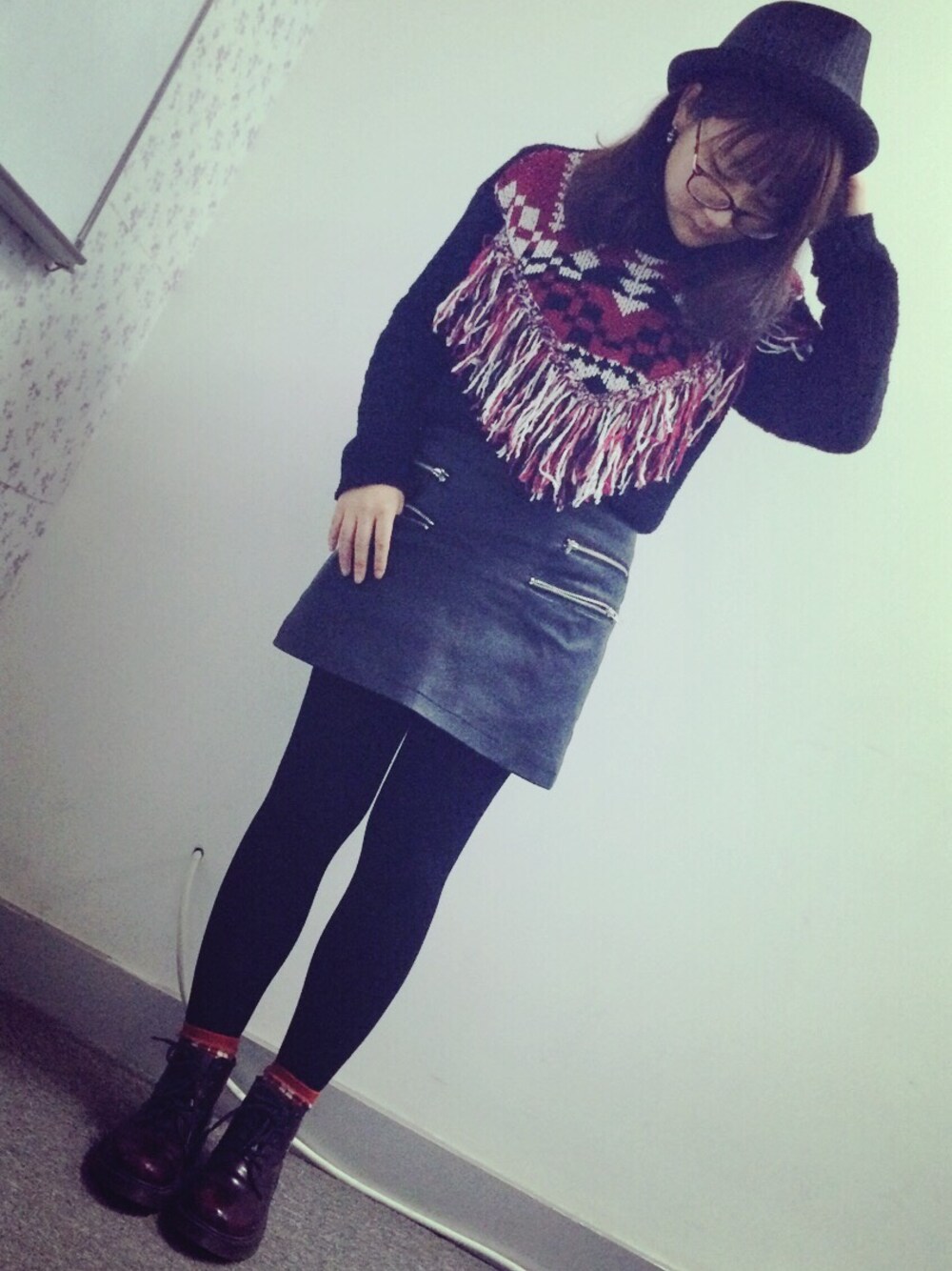 レッド系のニット/セーター、ブラック系のスカートを着用したレディースの冬コーディネートの1枚目の写真