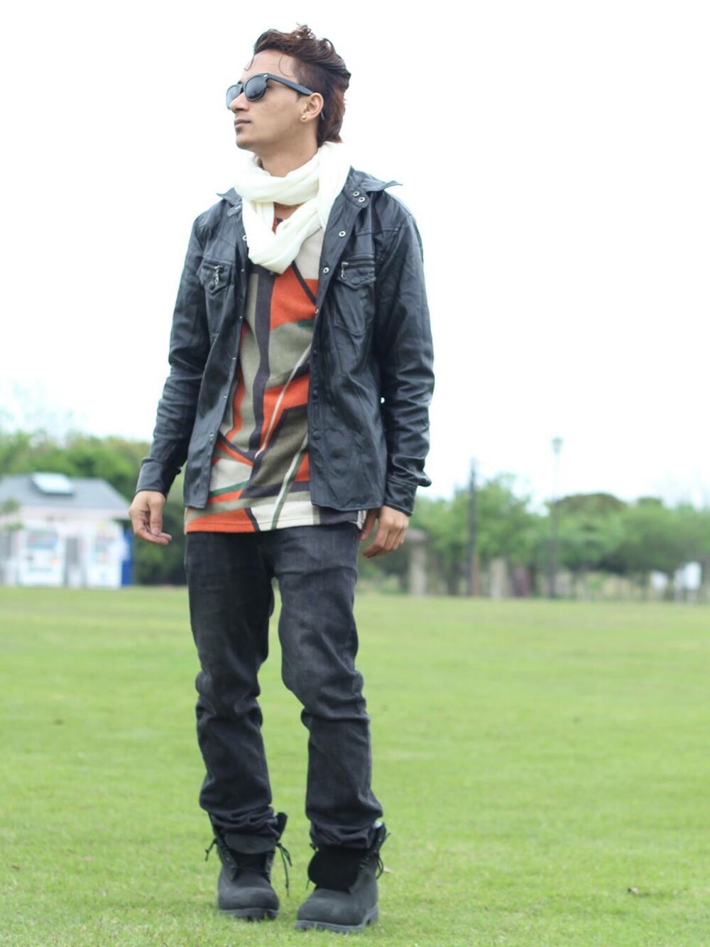 ブラック系のブーツ、オレンジ系のTシャツ/カットソー、ブラック系のライダースジャケットを着用したメンズの夏コーディネートの1枚目の写真