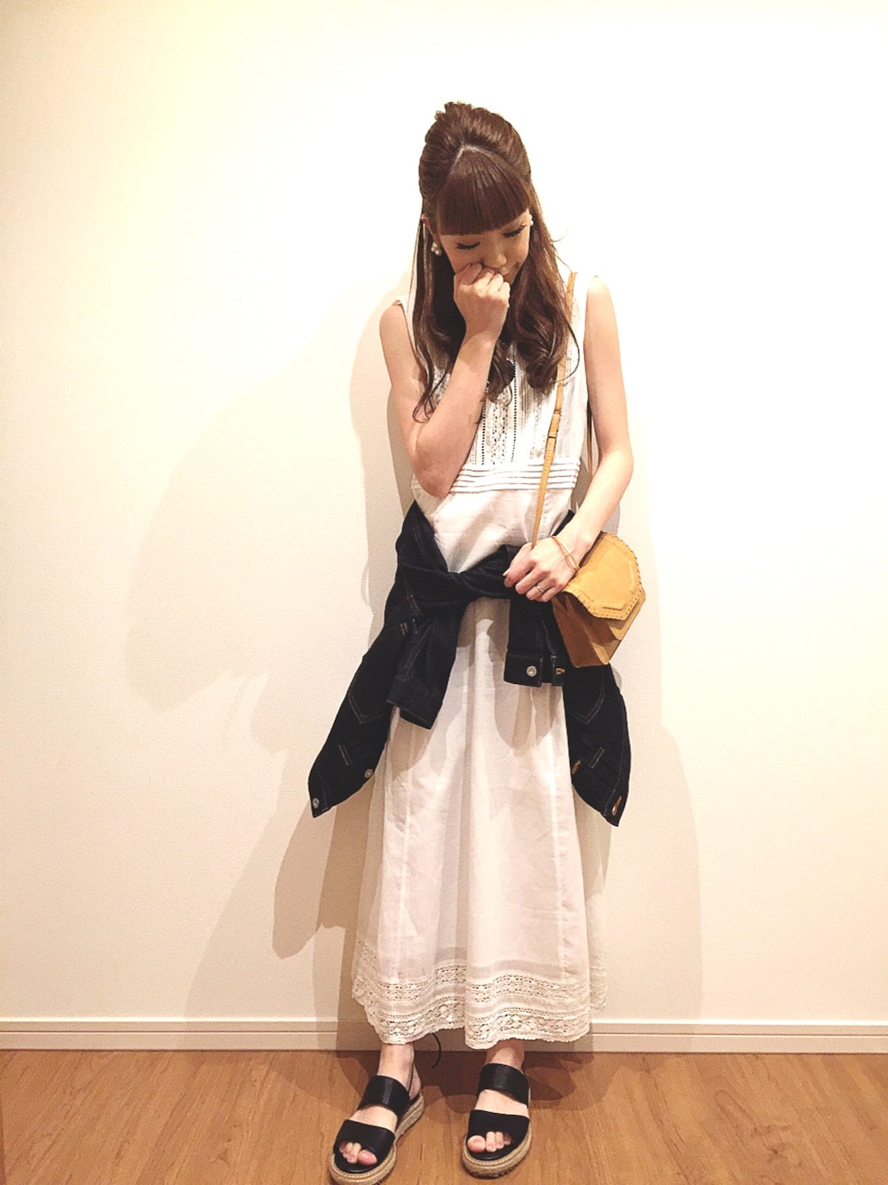 ホワイト系のワンピース、ブラック系のチューブトップ、ブルー系のデニムジャケットを着用したレディースの春コーディネートの1枚目の写真