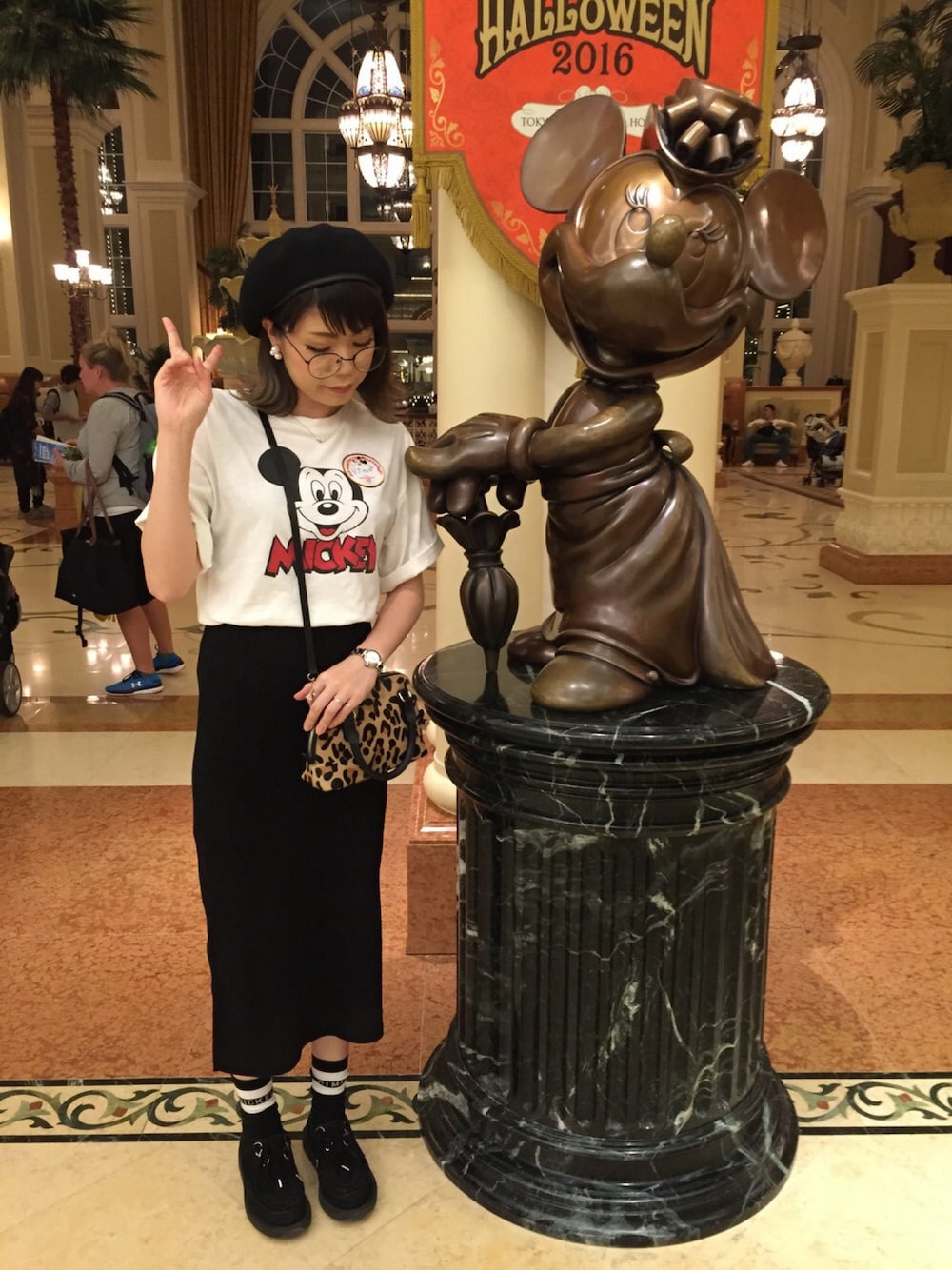 ホワイト系のTシャツ/カットソー、ブラック系のスカート、ブラウン系のハンドバッグを着用したレディースの秋コーディネートの1枚目の写真