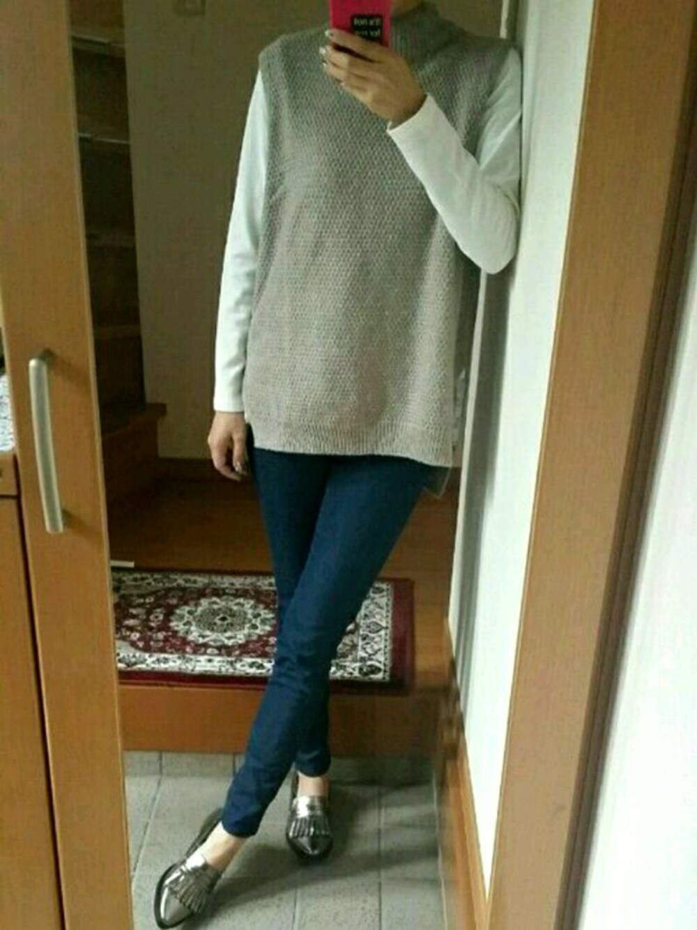 ブルー系のデニムパンツ、ホワイト系のTシャツ/カットソー、ベージュ系のベストを着用したレディースの秋コーディネートの1枚目の写真